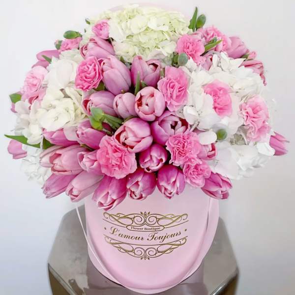 Pink and white tulips with carnations in a pink hatbox