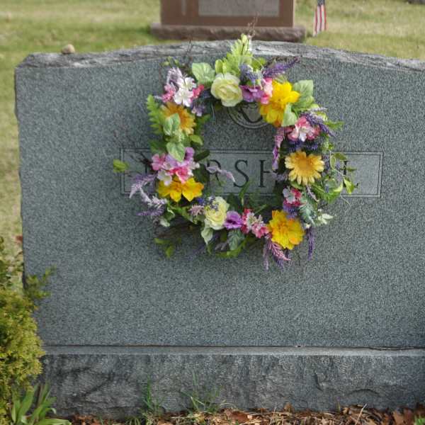 Colorful floral wreath on a gray gravestone