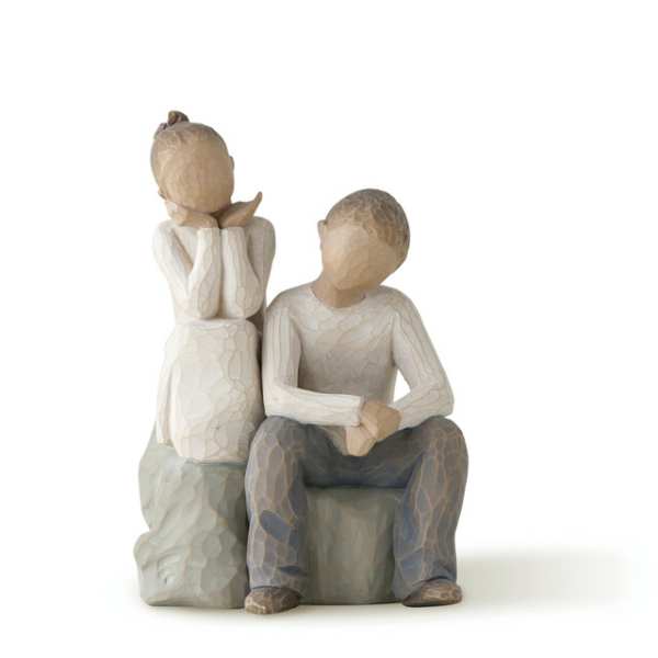 Two carved figurines of children sitting together