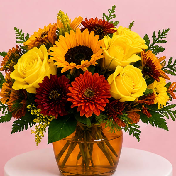 Bouquet of yellow roses and orange-red daisies in an amber glass vase
