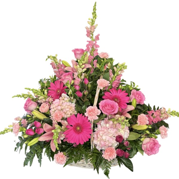 Pink mixed flower arrangement in a white basket