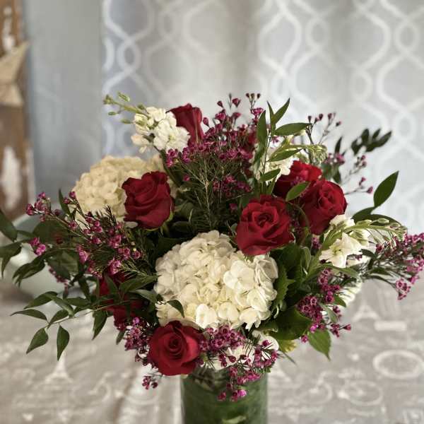 Red roses and white hydrangeas in a glass vase