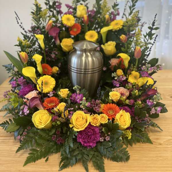Colorful floral wreath around a silver urn centerpiece