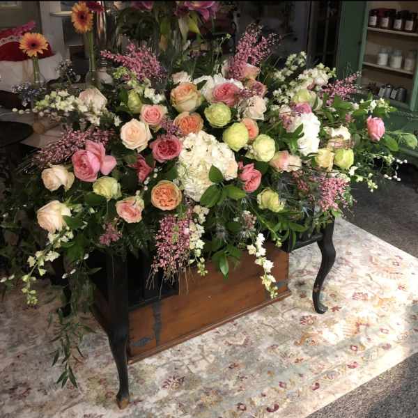 Large floral casket spray with pink and peach roses