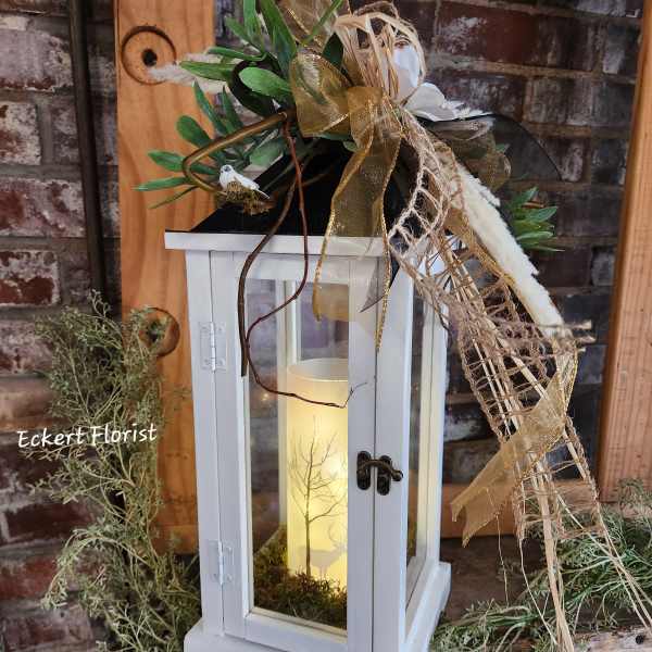 White lantern with candle and gold ribbon decoration