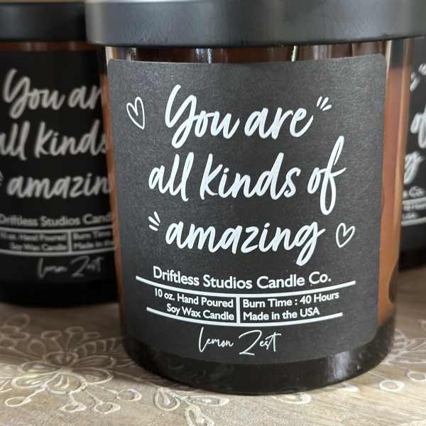 Black jar candle with a label reading "You are all kinds of amazing"