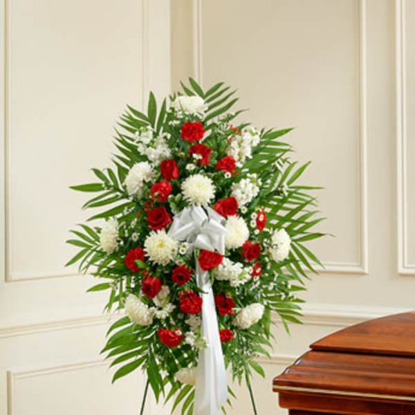 Standing floral spray with red and white flowers on an easel