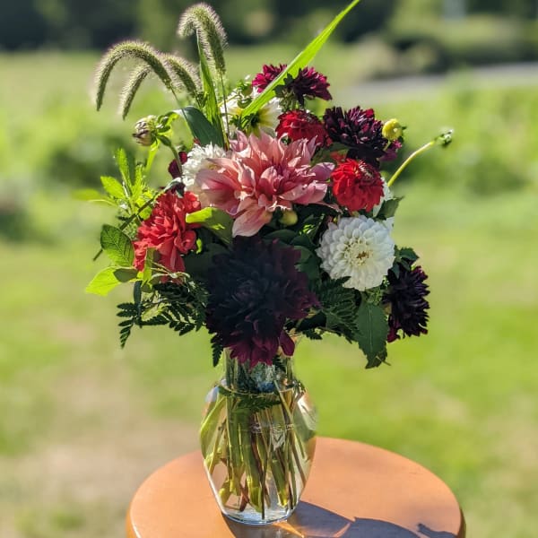Mixed bouquet of dahlias and chrysanthemums in a clear glass vase