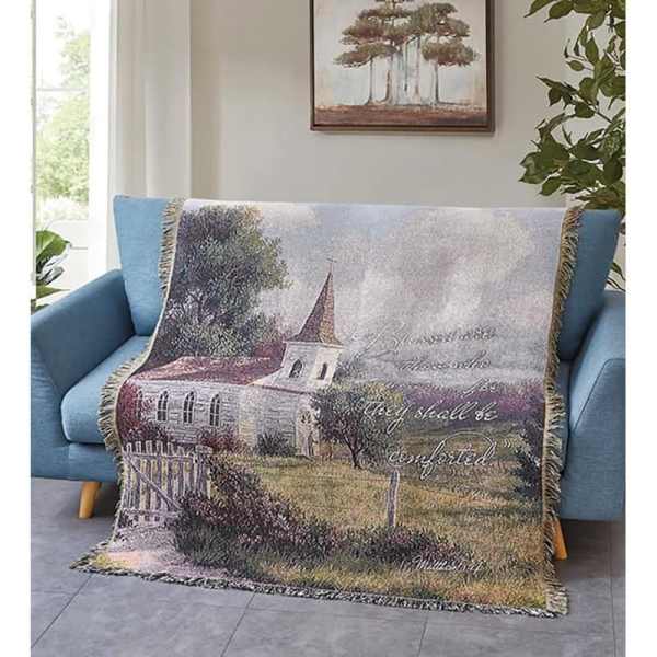 Throw blanket with a church scene draped over a blue sofa