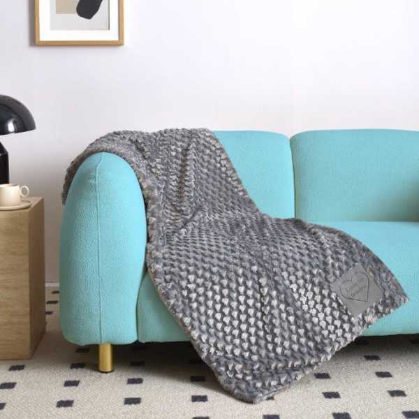 Gray textured throw blanket draped over a turquoise sofa