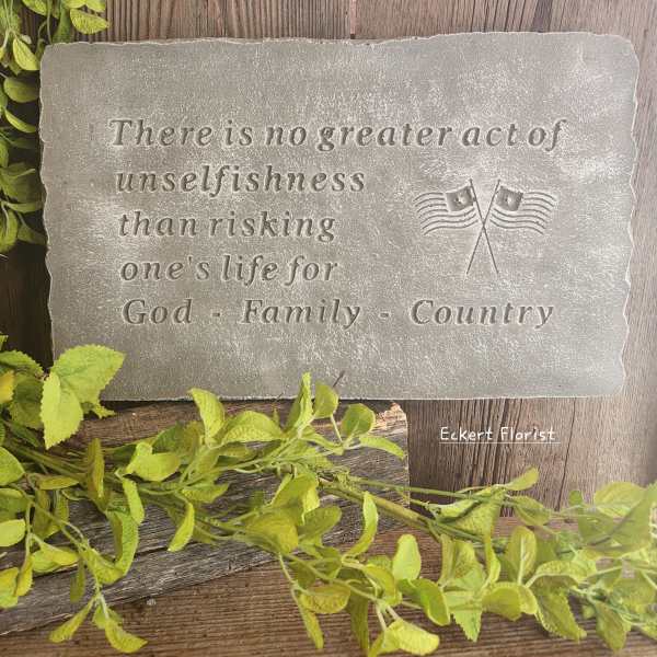 Engraved stone plaque with a patriotic quote and small flag emblem