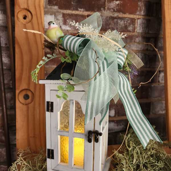 Decorative white lantern with ribbon and a small bird figurine