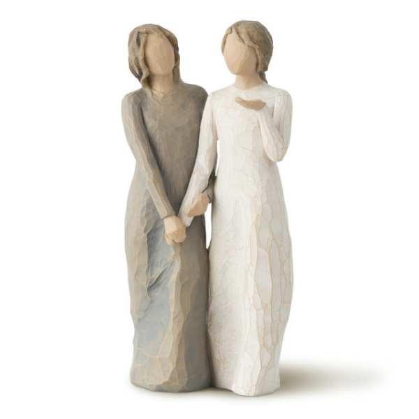 Two faceless carved figurines standing side by side