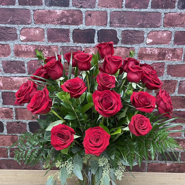 Red roses arranged in a clear glass vase