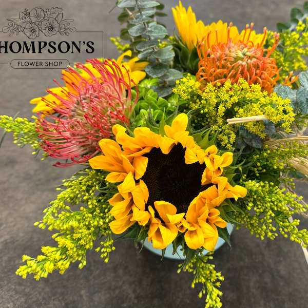 Bright mixed bouquet with a sunflower and pink, orange, and yellow blooms