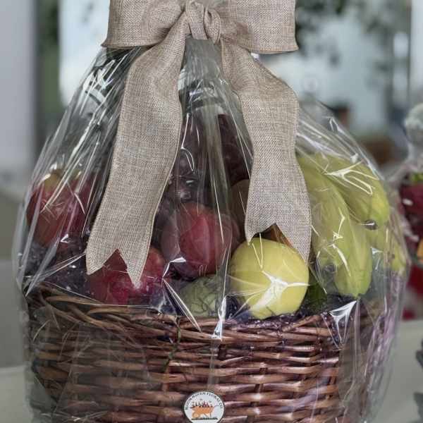 Wrapped fruit basket in a wicker container with a beige bow