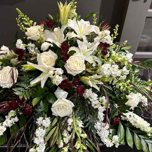 Large white and burgundy floral spray with lilies and roses