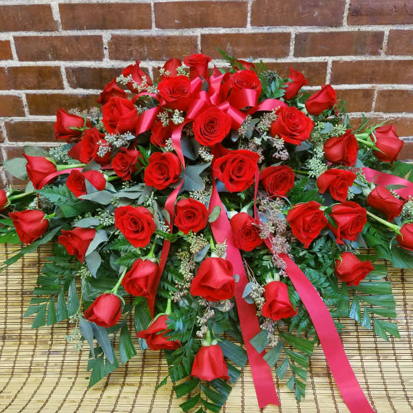Large arrangement of red roses with pink ribbons