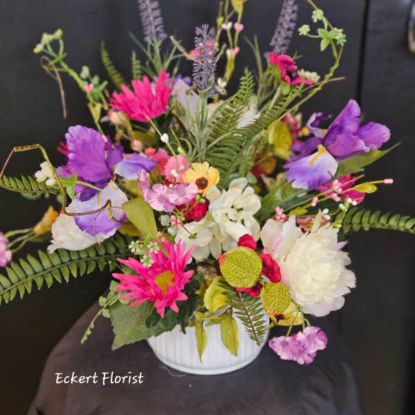 Colorful mixed bouquet in a white vase with purple, pink, and white blooms