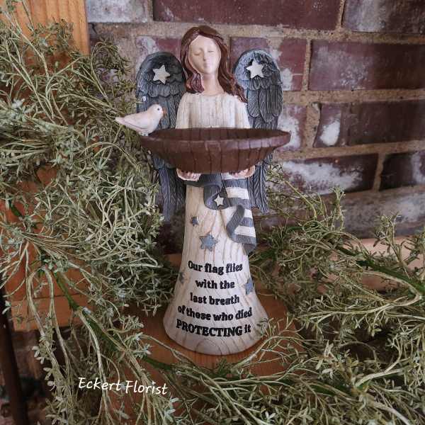 Angel figurine holding a bowl with a small bird beside it