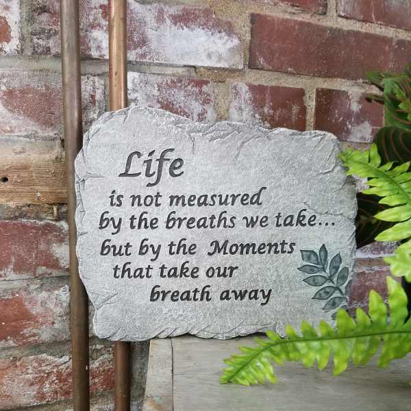 Stone plaque with a quote against a brick wall