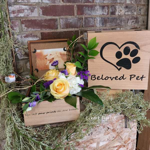 Yellow and purple rose arrangement beside a wooden pet memorial sign