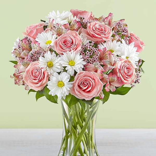 Pink roses and white daisies in a clear glass vase