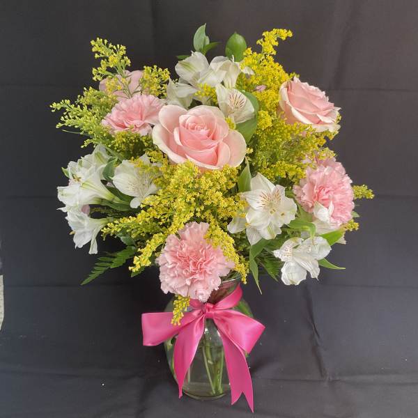 Pink roses and carnations with white alstroemeria in a glass vase