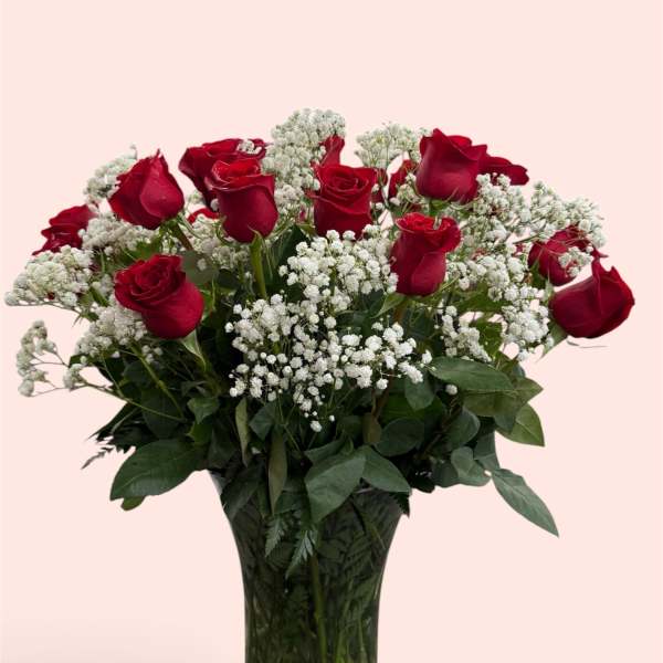 Red roses and white baby's breath in a clear glass vase