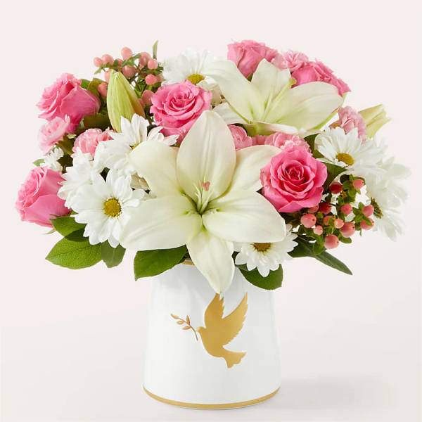 Pink roses and white lilies in a white vase with a gold dove design