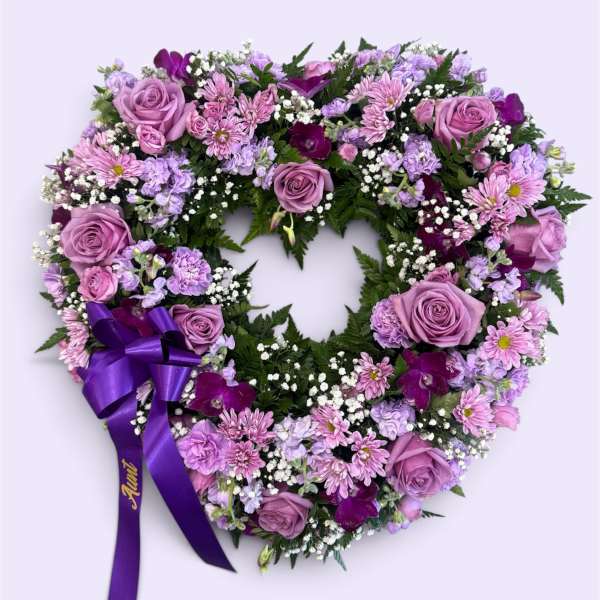 Heart-shaped floral wreath with lavender roses and purple ribbon