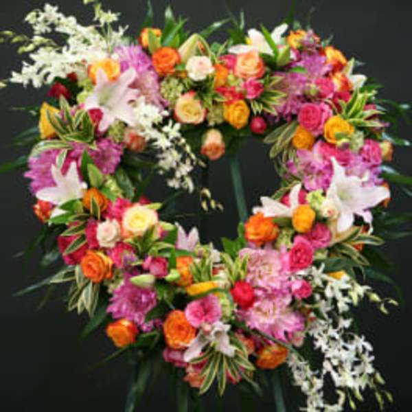 Heart-shaped floral wreath with pink, orange, and white blooms