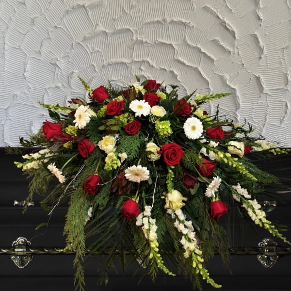 Red and white floral casket spray with roses and daisies