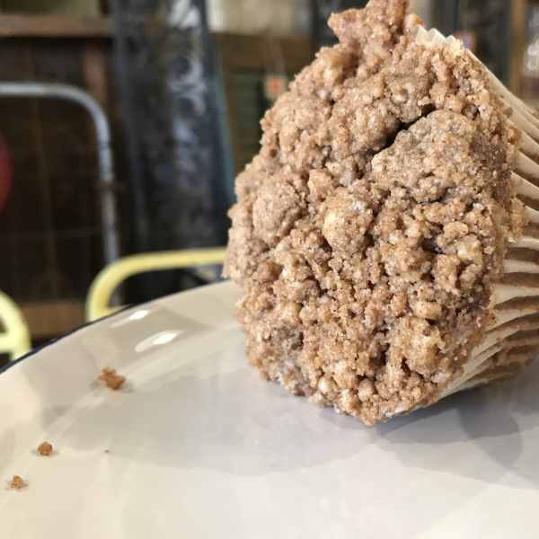 Two crumb-topped muffins on a white plate