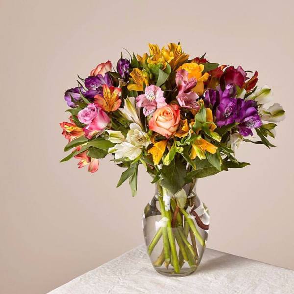 Mixed bouquet of colorful flowers in a clear glass vase