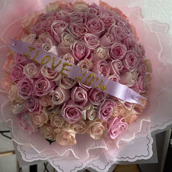 Pink rose bouquet with a lavender ribbon reading "I LOVE YOU"