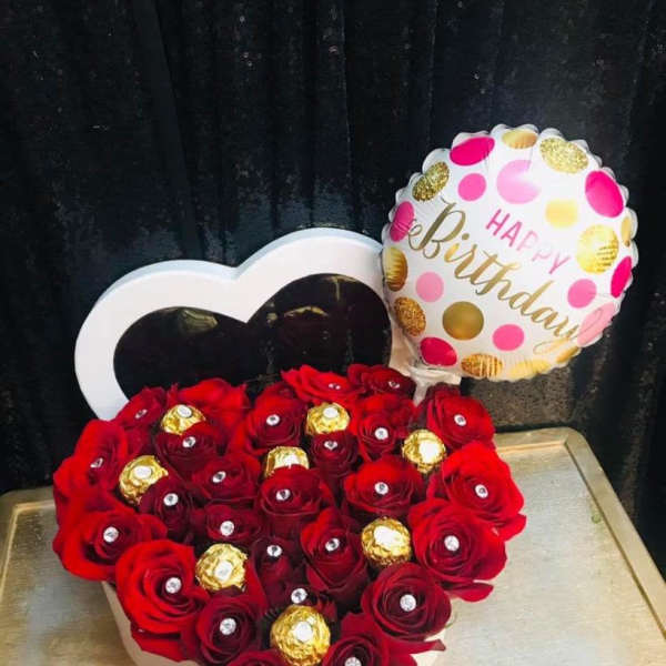 Heart-shaped box of red roses with a birthday balloon