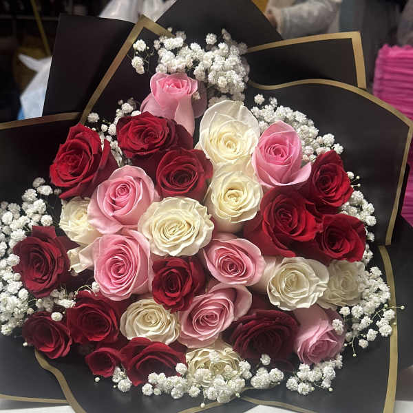 Bouquet of red, pink, and white roses with baby's breath in black wrap