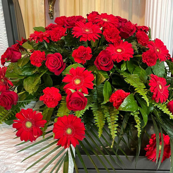 Red roses and gerbera daisies arranged in a casket spray