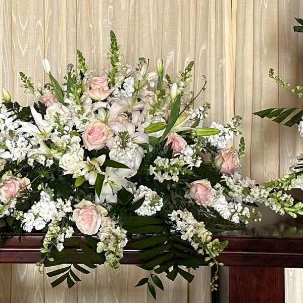 Large white and blush floral casket spray with lilies and roses
