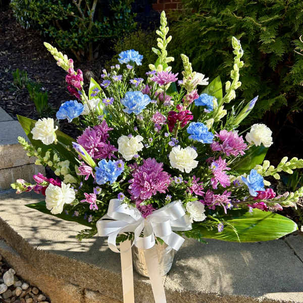 Colorful mixed bouquet in a silver vase with a white ribbon