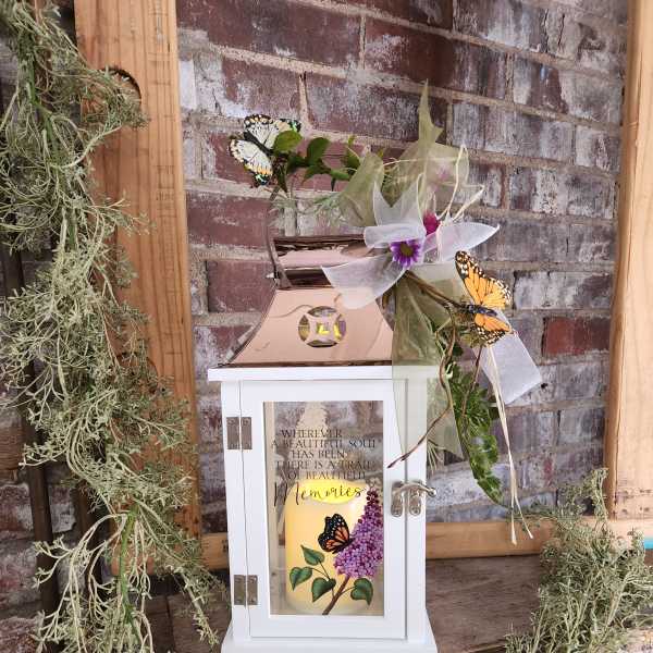 Decorative memorial lantern with a candle, ribbon, and butterfly accents