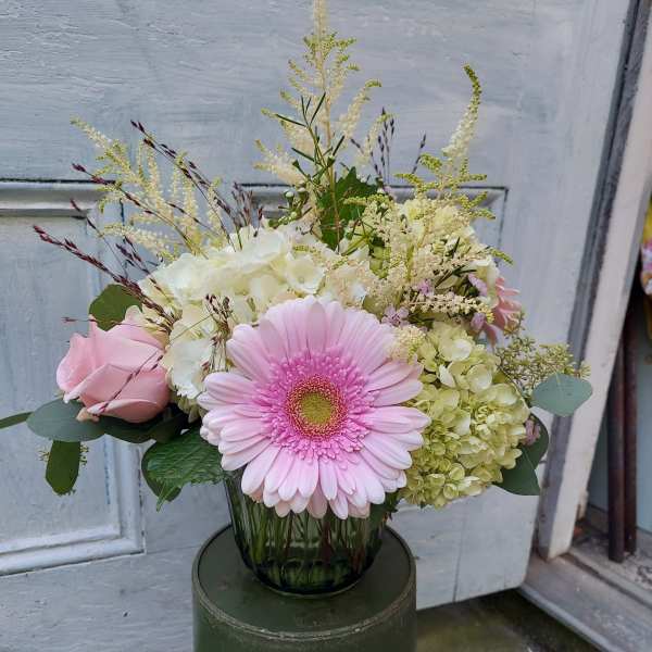 Pink gerbera daisy and roses in a glass vase
