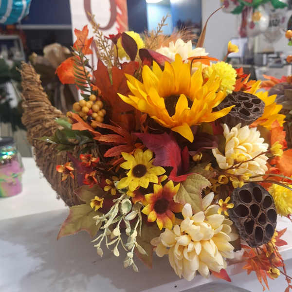 Autumn floral arrangement with sunflowers and cream mums in a woven basket
