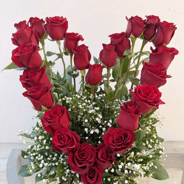Heart-shaped arrangement of red roses with baby's breath