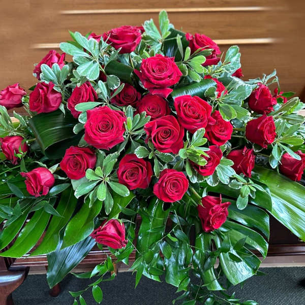 Large arrangement of red roses with broad green foliage