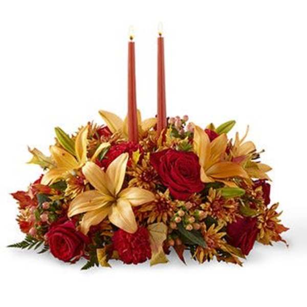 Autumn floral centerpiece with red roses and two taper candles