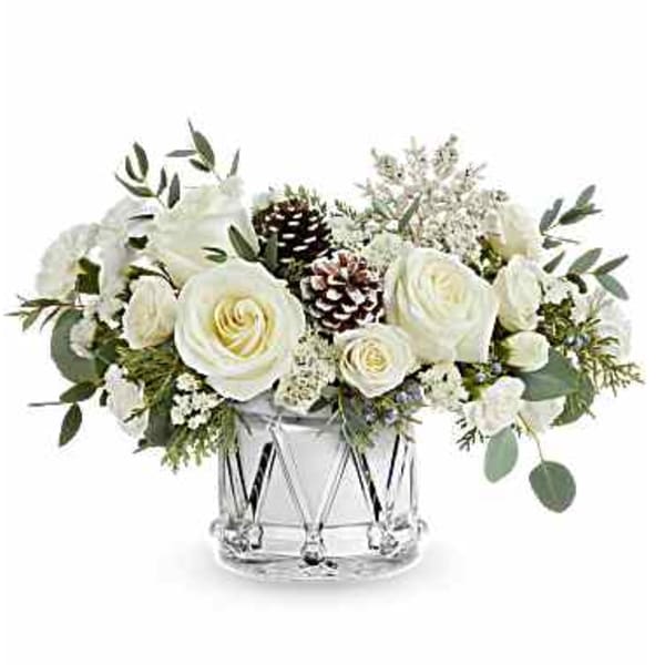White roses and pinecones arranged in a clear glass vase