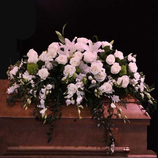 White floral casket spray with roses and lilies