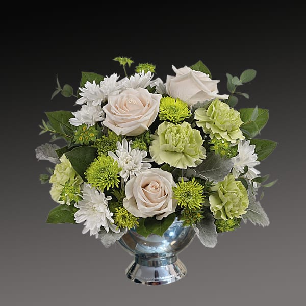 Bouquet of cream roses, white daisies, and green carnations in a silver vase